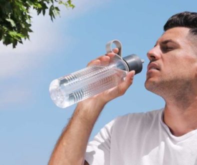 Illustration of a person staying cool under a shaded tree on a sunny day, how to prevent heat stroke