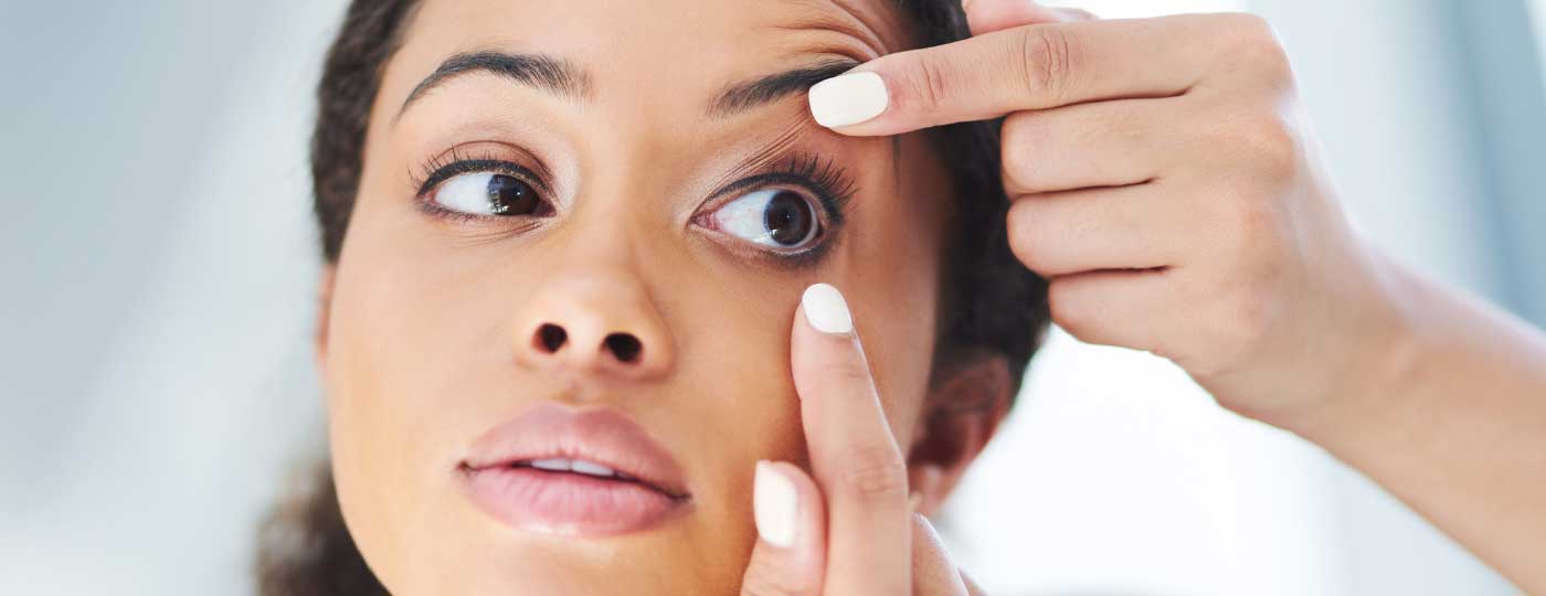 A person holding a soft contact lens, demonstrating proper soft contact lens fitting.