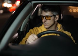 A pair of night driving glasses with yellow-tinted lenses for enhanced visibility in low-light conditions.