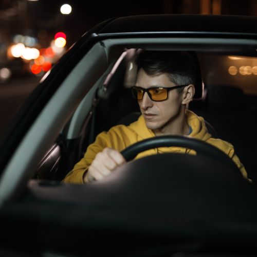A pair of night driving glasses with yellow-tinted lenses for enhanced visibility in low-light conditions.